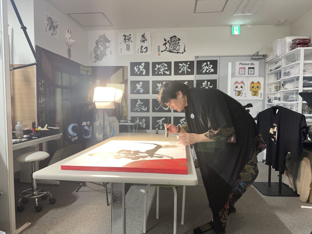 Japanese calligraphy artist Madara creating custom artwork using the Hisseki-jutsu technique