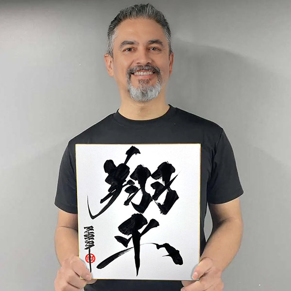 色紙の書道作品を持つお客様の写真