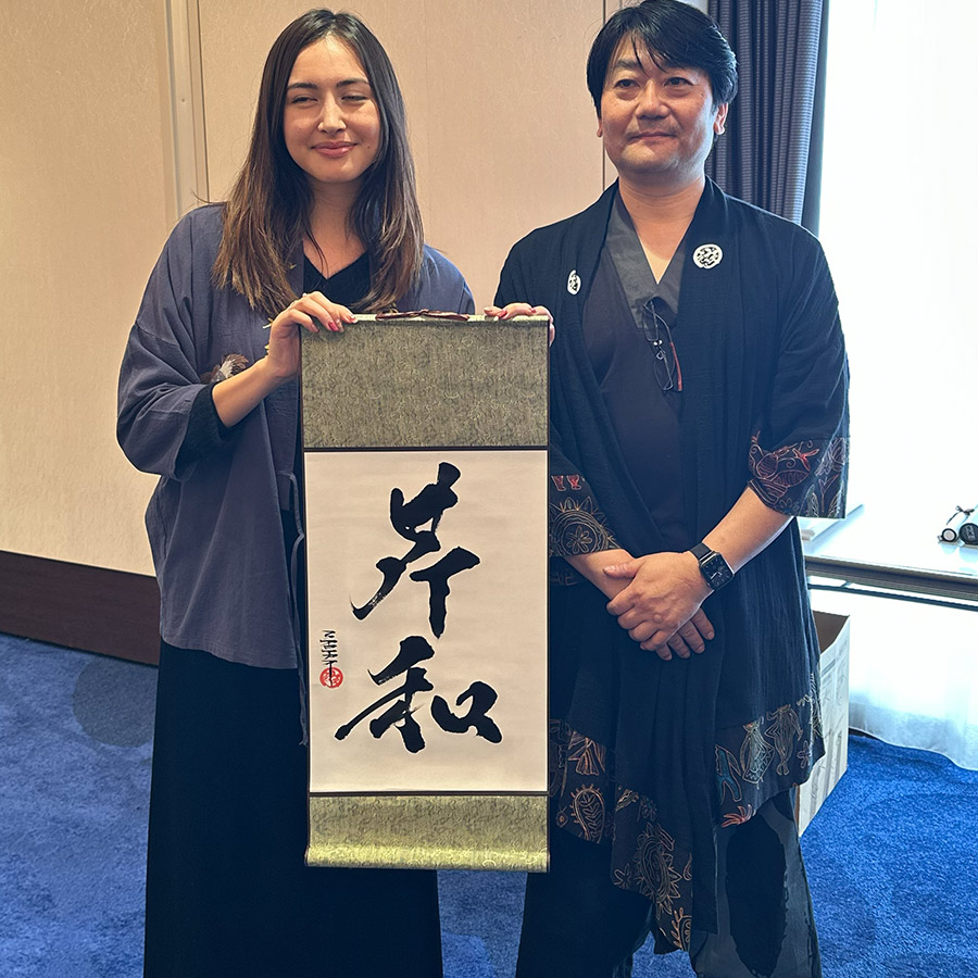 掛け軸の書道作品を持つ海外のお客様の写真